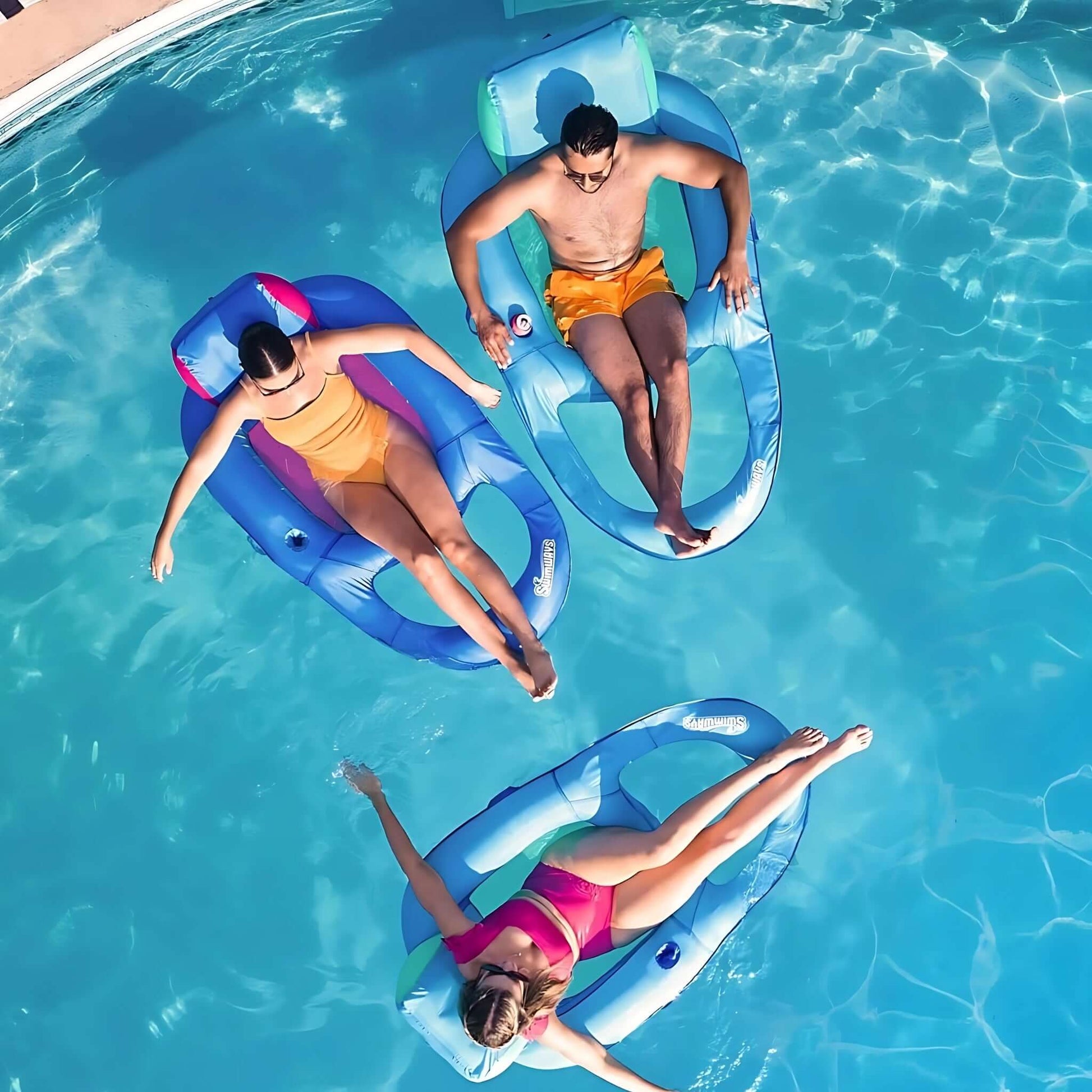 SwimWays Premium Spring Float Recliner by Discount Pool Mart DPM - Three loungers in a pool, perfect for summer relaxation.