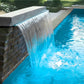 CMP Natural Wonders 18" x 6" Lip White Waterfall 25577-180-000 cascading into clear pool water, enhancing pool landscape.