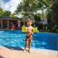 Toddler wearing Intex Dinosaur Arm Bands by Discount Pool Mart DPM, enjoying at poolside in sunny weather, SKU 32132J.