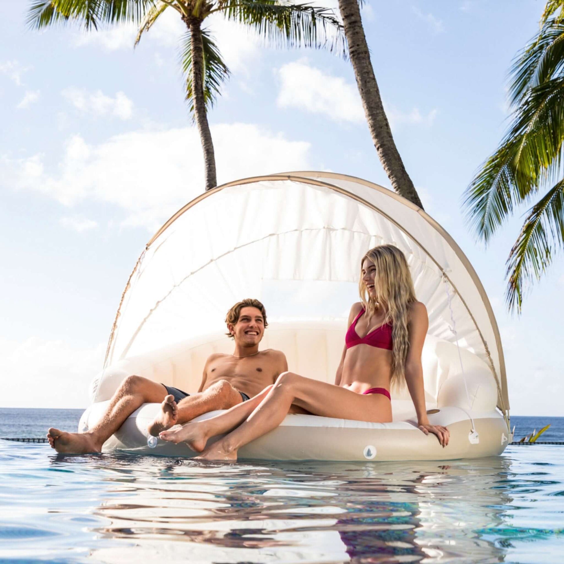 Couple relaxing on INTEX Canopy Island Inflatable Pool Float, SKU 58292EP, from Discount Pool Mart DPM. Resort-style lounging.