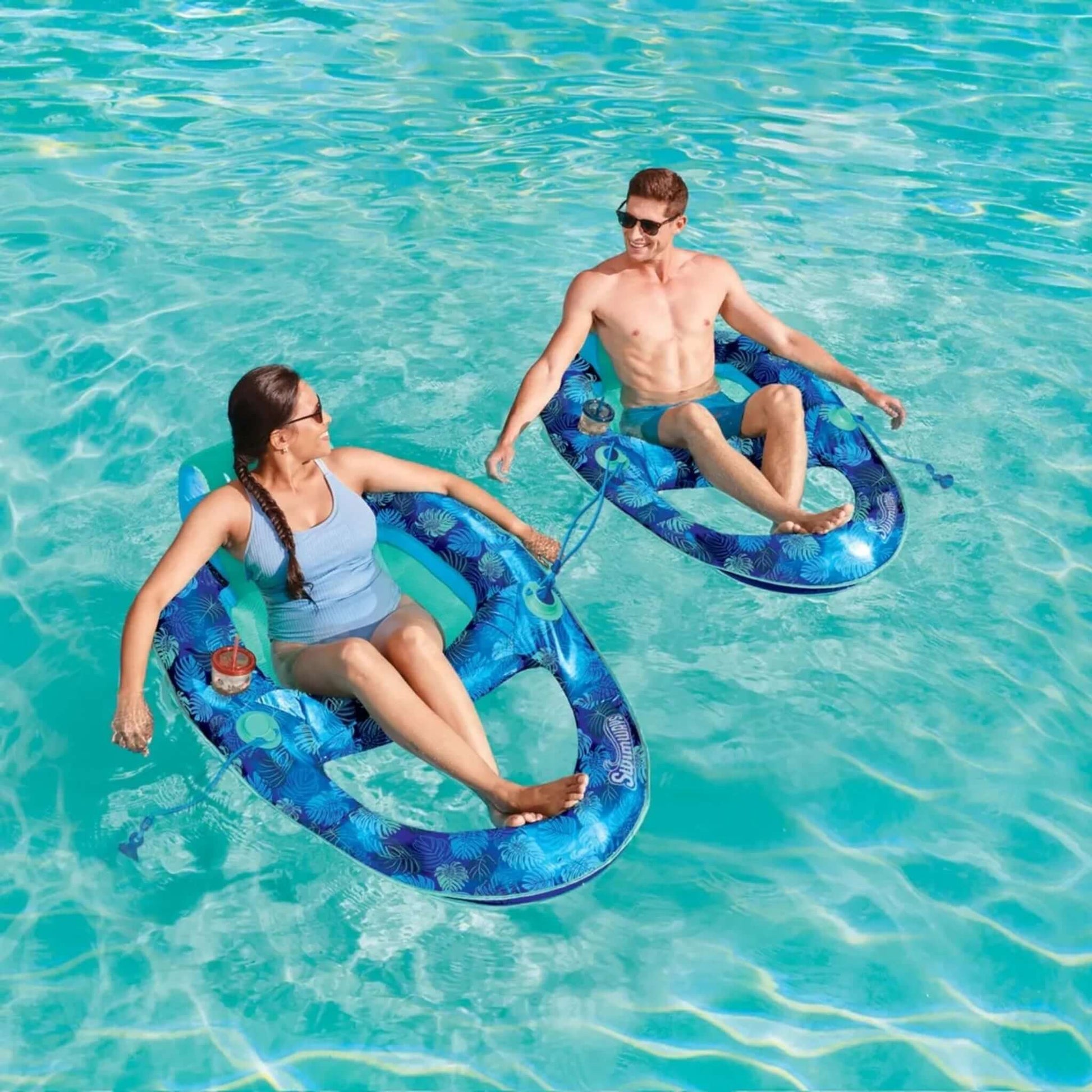 Two people enjoying the SwimWays Elite Spring Float Recliner in a pool at Discount Pool Mart (DPM) SKU 6069308.