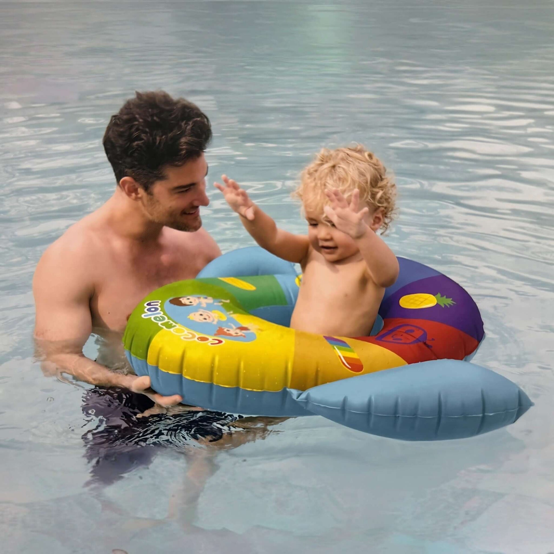 Toddler enjoying the SwimWays Cocomelon Inflatable Baby Boat with adult in water. SKU: 6071744 from Discount Pool Mart DPM.