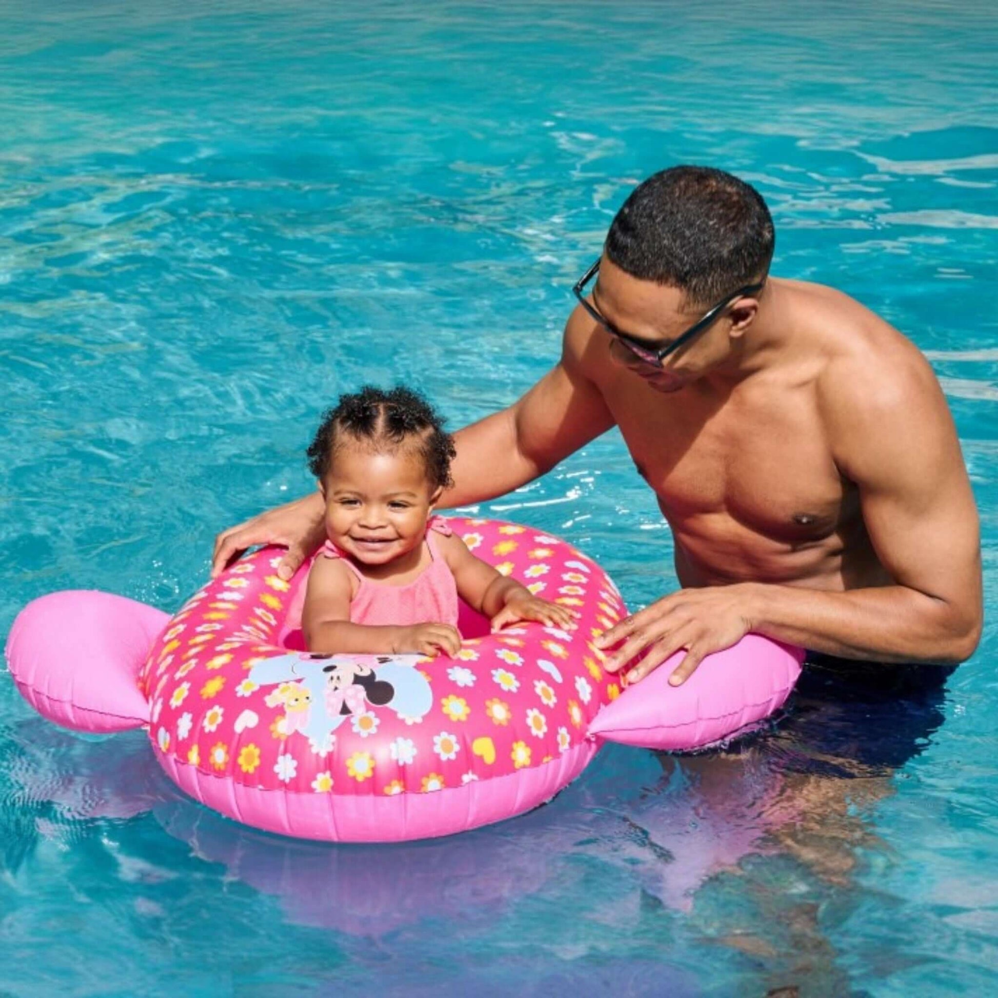 Toddler enjoying the SwimWays Minnie Inflatable Baby Boat in the pool with parent, SKU 6071745, Discount Pool Mart DPM.