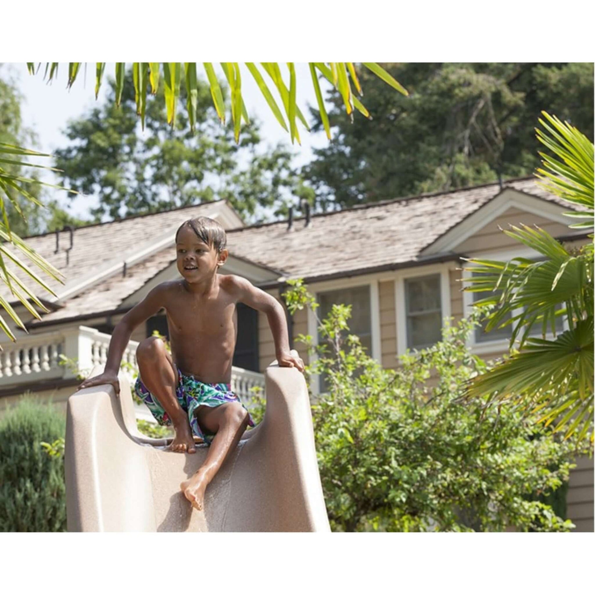 Child enjoying the Typhoon Pool Slide from Discount Pool Mart DPM. Perfect for summer fun in your backyard.