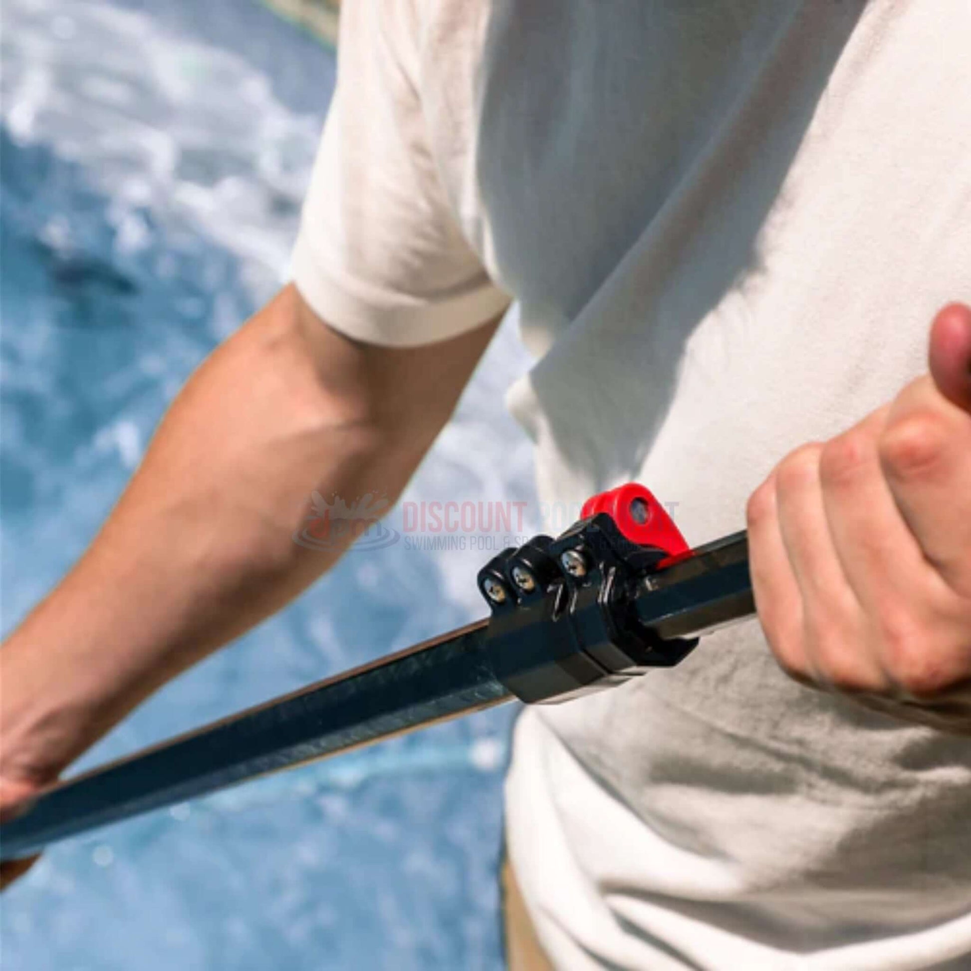 User gripping the Skimlite Carbonlite Pool Pole Lever Lock CL820L | 7.5'-20' near a swimming pool, showcasing its robust locking mechanism.
