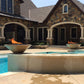 Outdoor Plus Cazo Fire Bowl GFRC Concrete by Discount Pool Mart DPM with flames in outdoor setting.