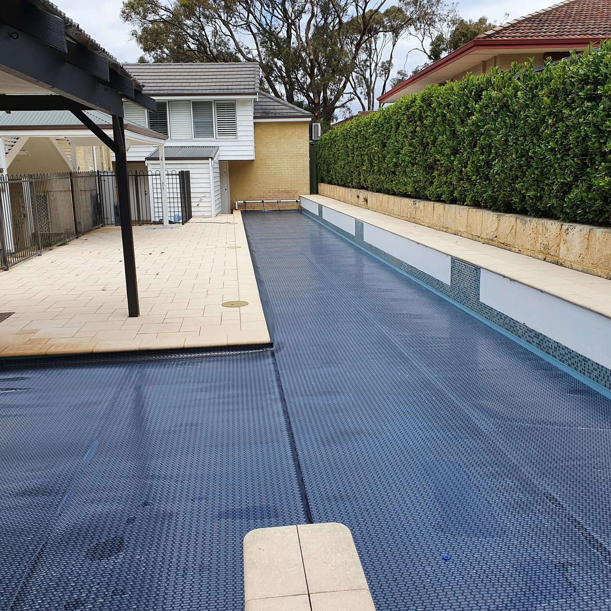 EnergyGuard™ GeoBubble™ solar cover installed on a rectangular inground swimming pool.