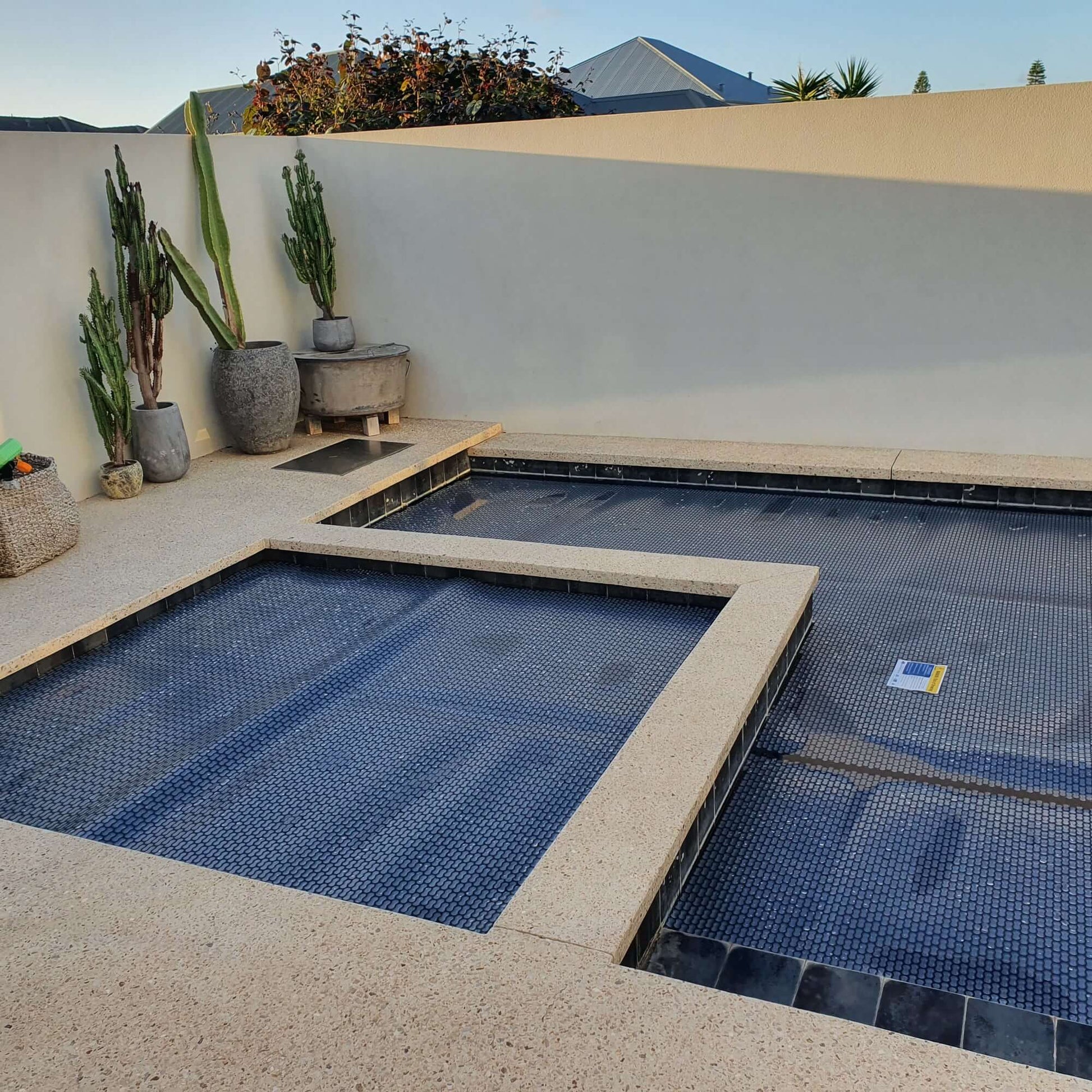 Sunset view of an inground pool protected with the EnergyGuard™ solar pool cover.