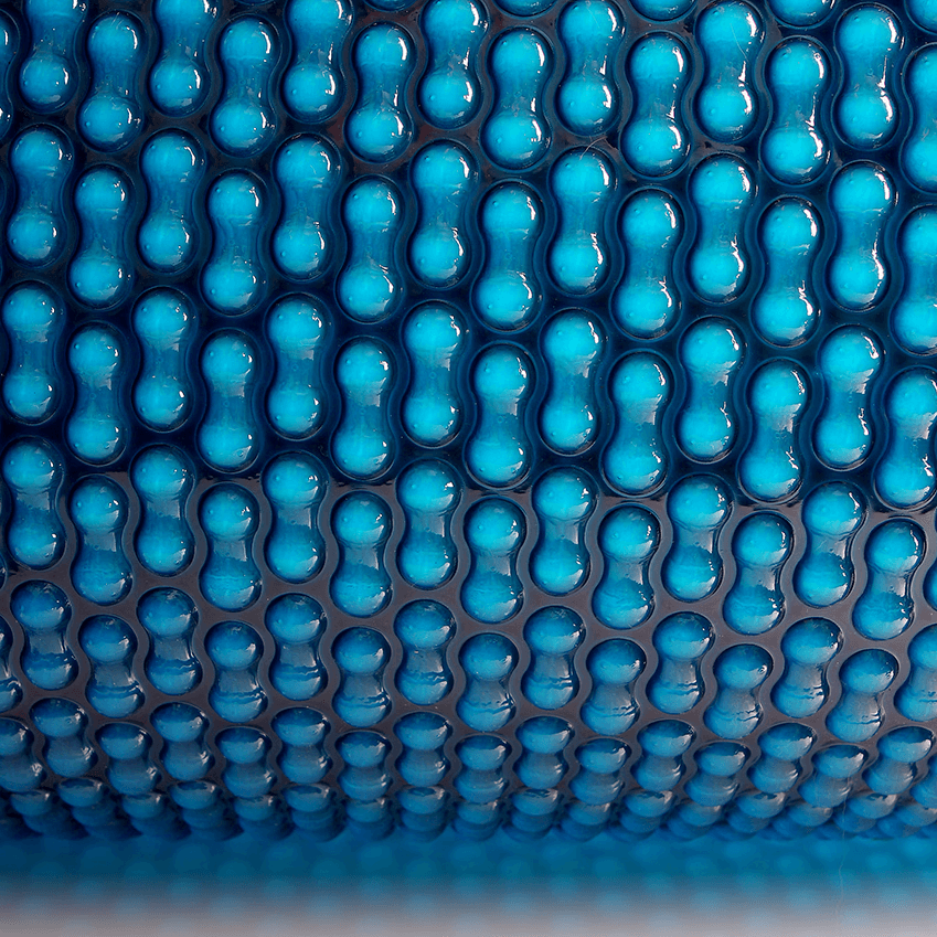 Top-down view of the blue EnergyGuard™ solar pool cover showing surface texture and color.