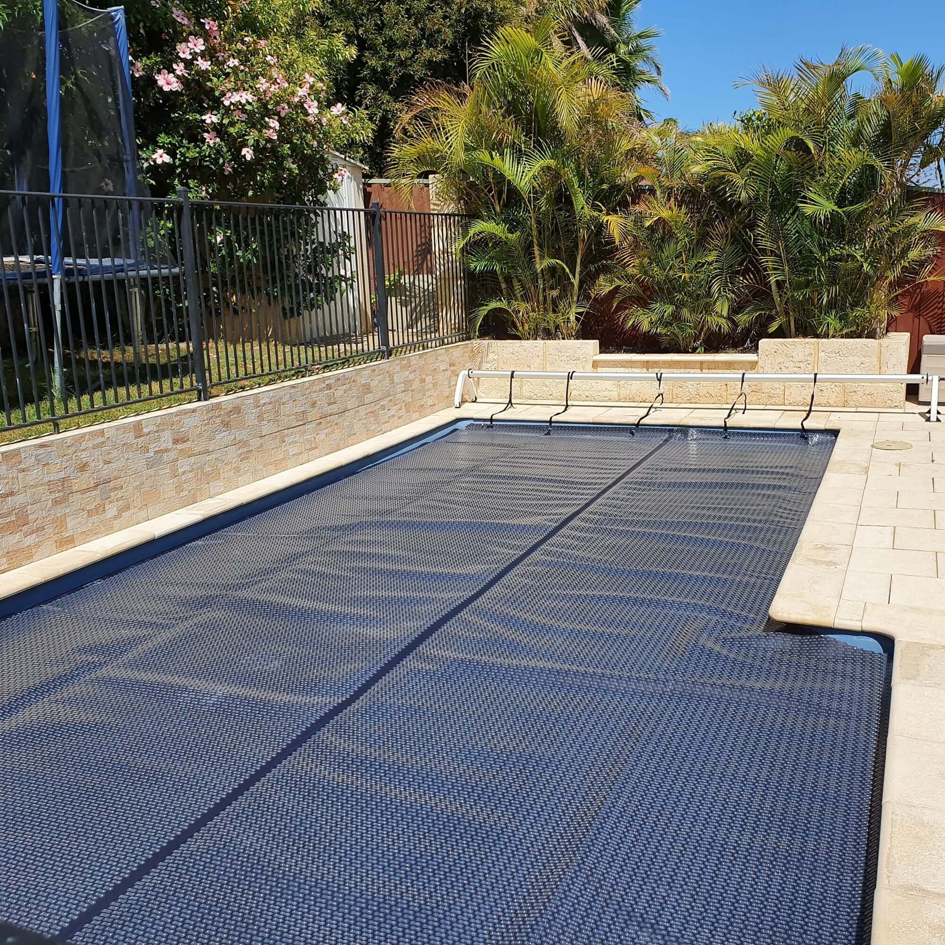 Full view of EnergyGuard™ cover on a residential in-ground pool, demonstrating neat edge-to-edge fit.